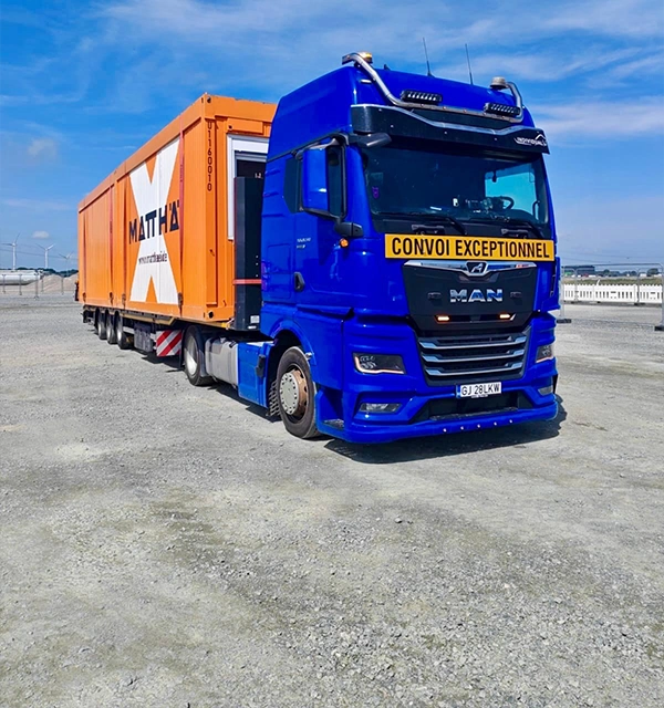 Camion MAN si semi-trailer incarcat cu un container modular