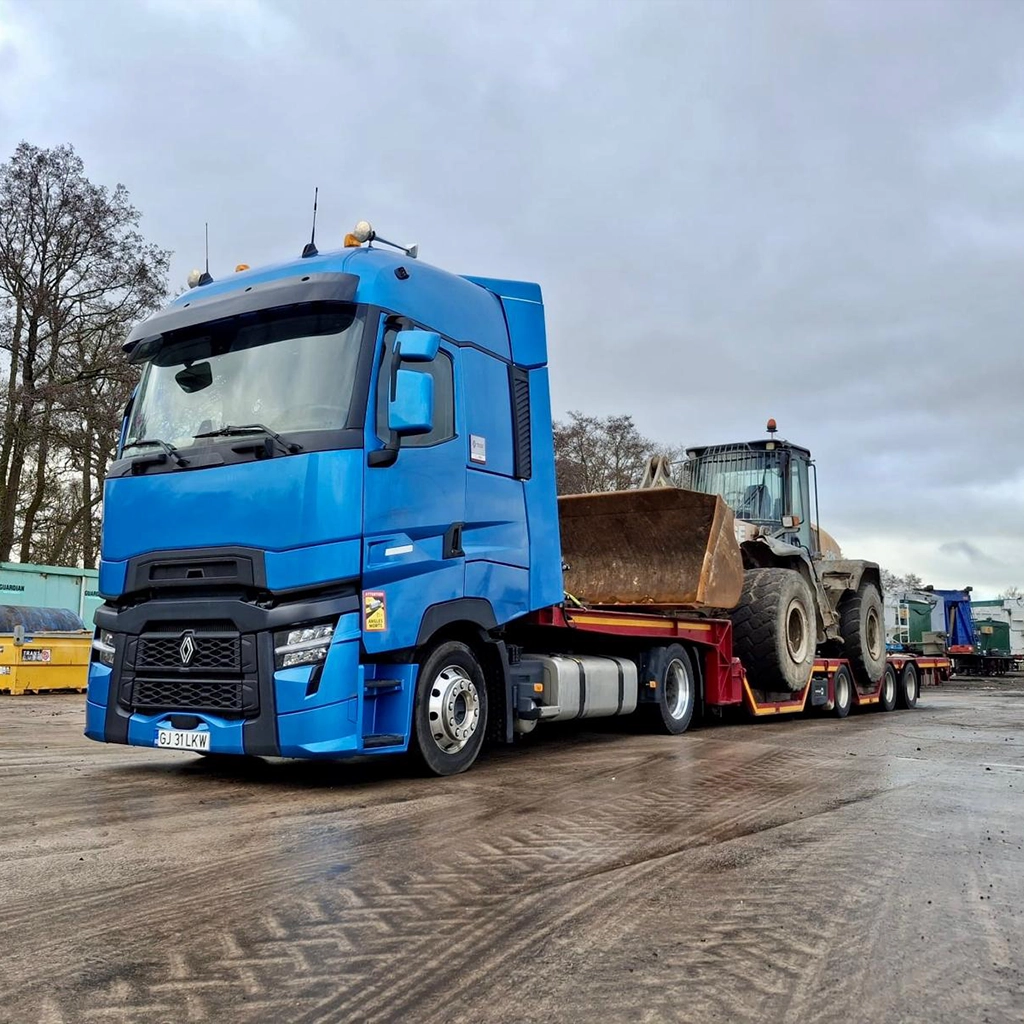 Camion Renault si semi-trailer cu alveole ce e incarcat cu un incarcator frontal
