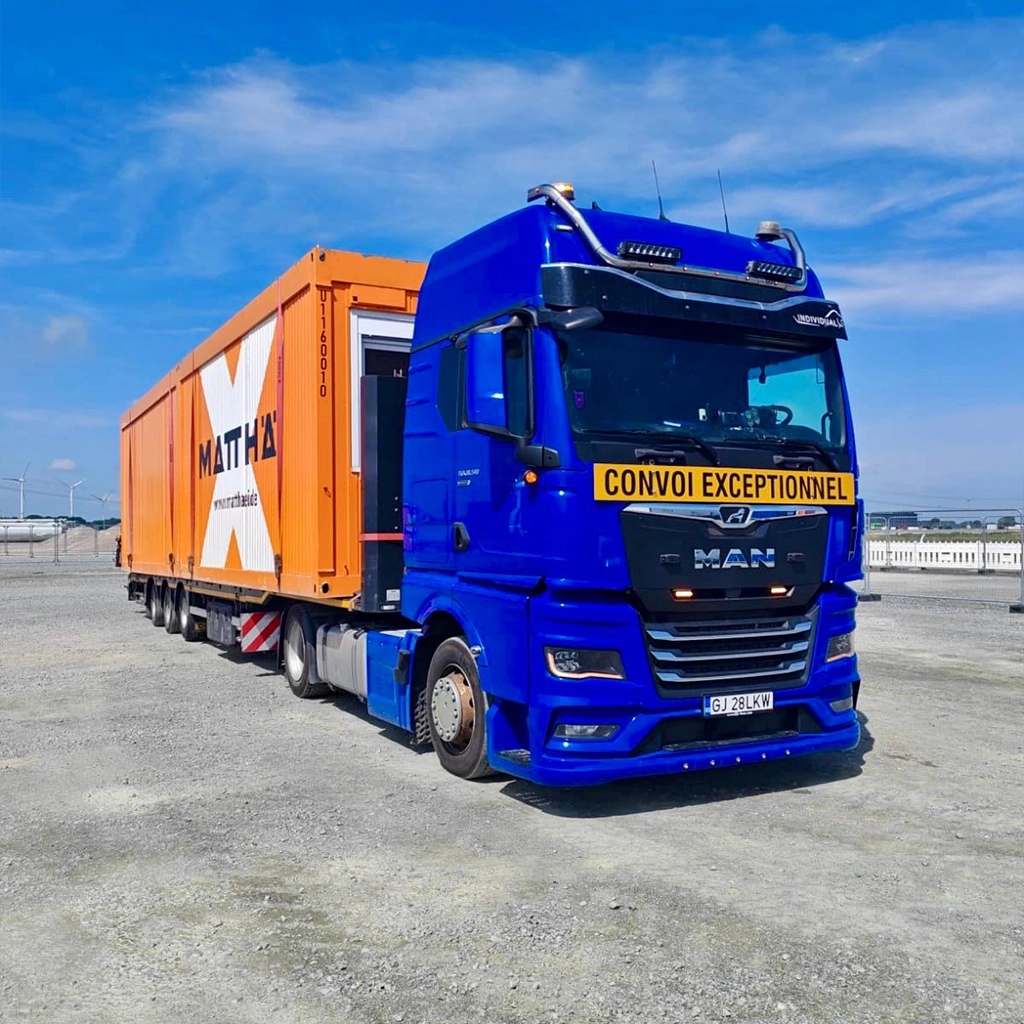 Camion MAN albastru si un semi-trailer ce e incarcat cu un container